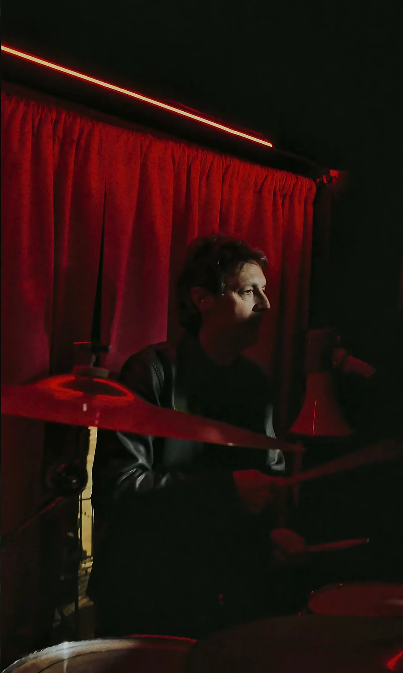 El baterista de MAGOS entre las luces rojas de Carnal Bar